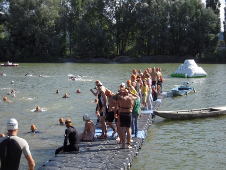 ein steg, die donau und menschen im wasser